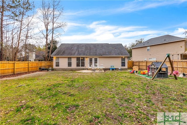 rear view of property with a playground and a lawn