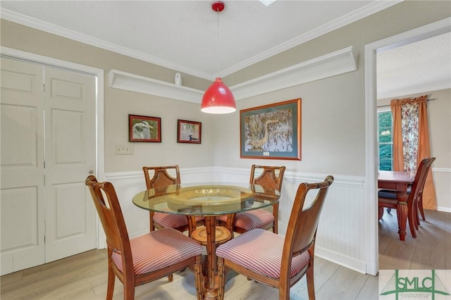 dining room featuring ornamental molding and light hardwood / wood-style floors