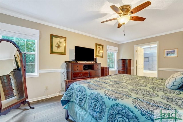 bedroom featuring multiple windows, hardwood / wood-style floors, ceiling fan, and ensuite bath