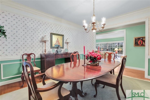 dining space featuring hardwood / wood-style flooring, ornamental molding, and a chandelier