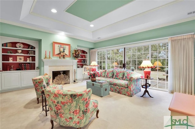 living room featuring built in shelves, a raised ceiling, and light carpet