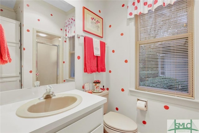 bathroom with a shower with door, vanity, and toilet