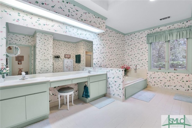 bathroom featuring vanity, a bath, and ornamental molding