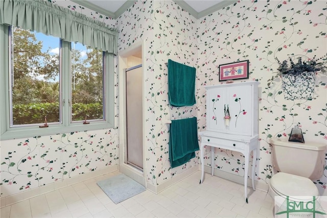 bathroom featuring a shower with door and toilet