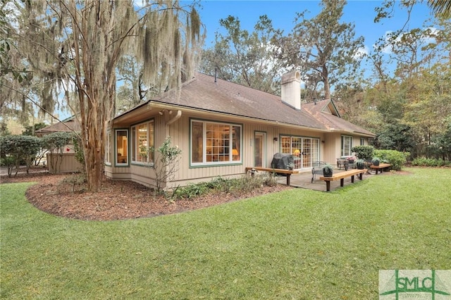 back of house featuring a lawn and a patio area