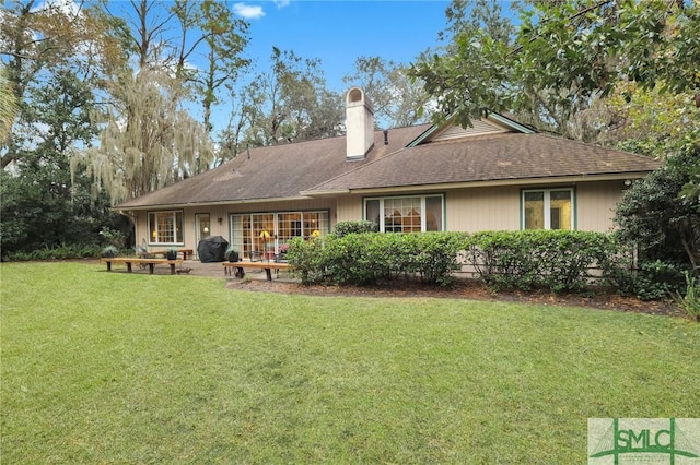 rear view of house featuring a lawn