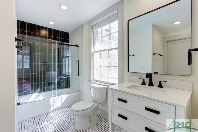 full bathroom featuring vanity, shower / bath combination with glass door, and toilet