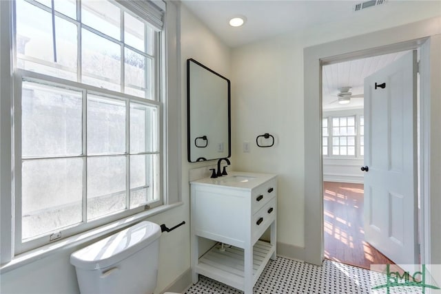 bathroom featuring vanity, a wealth of natural light, and toilet