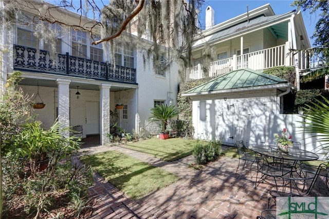 back of house featuring central AC, a balcony, and a patio