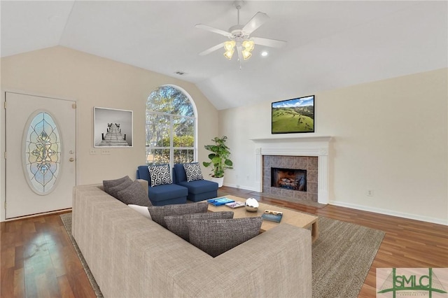 living room featuring a tiled fireplace, vaulted ceiling, hardwood / wood-style floors, and ceiling fan