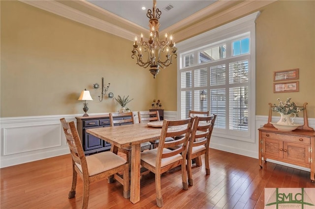 dining room featuring hardwood / wood-style floors, a notable chandelier, and ornamental molding