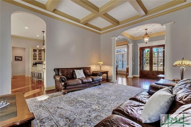 living room featuring decorative columns, coffered ceiling, crown molding, beam ceiling, and french doors