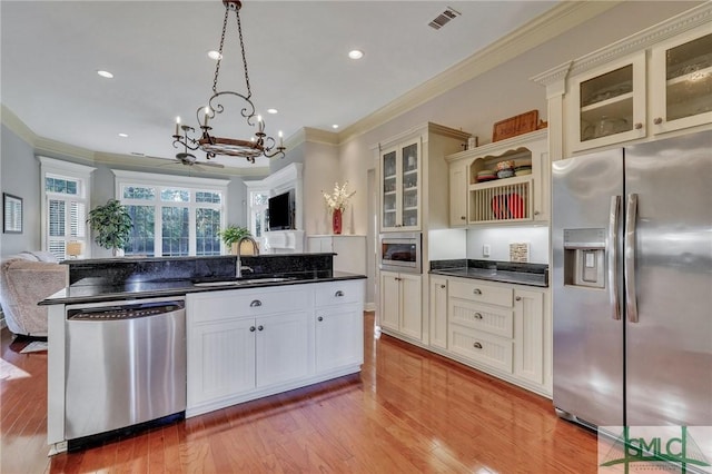 kitchen with sink, light hardwood / wood-style flooring, stainless steel appliances, ornamental molding, and decorative light fixtures