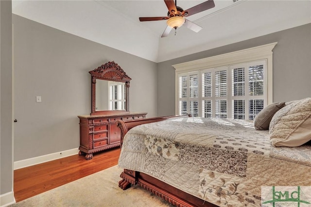 bedroom with hardwood / wood-style flooring, vaulted ceiling, and ceiling fan