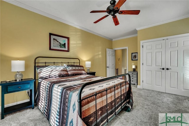 carpeted bedroom with ceiling fan, ornamental molding, and a closet