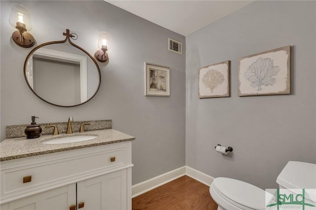 bathroom featuring vanity, toilet, and hardwood / wood-style floors