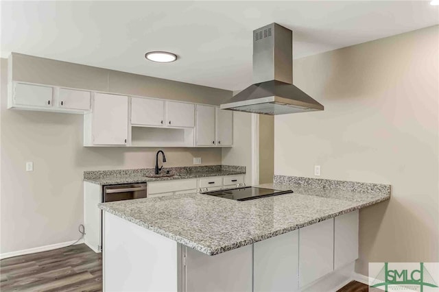 kitchen with white cabinetry, island exhaust hood, light stone countertops, and kitchen peninsula