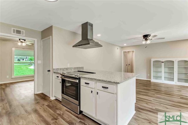 kitchen featuring white cabinetry, light hardwood / wood-style flooring, electric range, island exhaust hood, and light stone countertops