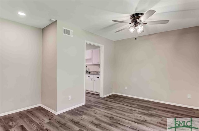 empty room featuring ceiling fan and dark hardwood / wood-style flooring