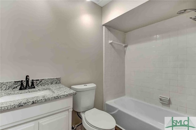 full bathroom featuring tiled shower / bath combo, vanity, and toilet