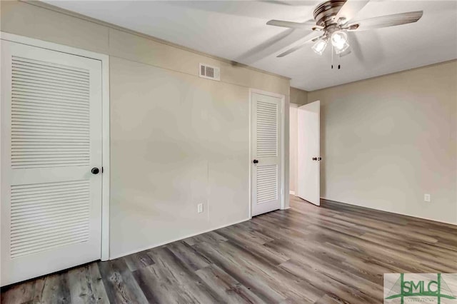 unfurnished bedroom with dark hardwood / wood-style floors and ceiling fan