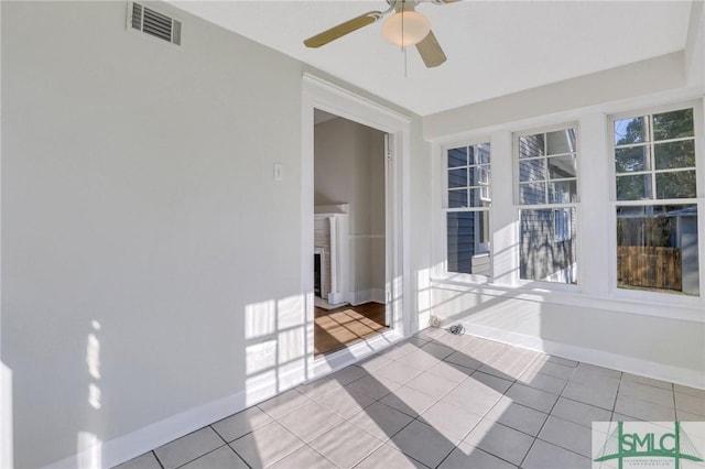 tiled spare room with ceiling fan