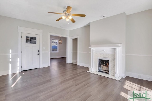 unfurnished living room featuring wood-type flooring, ceiling fan, and a fireplace