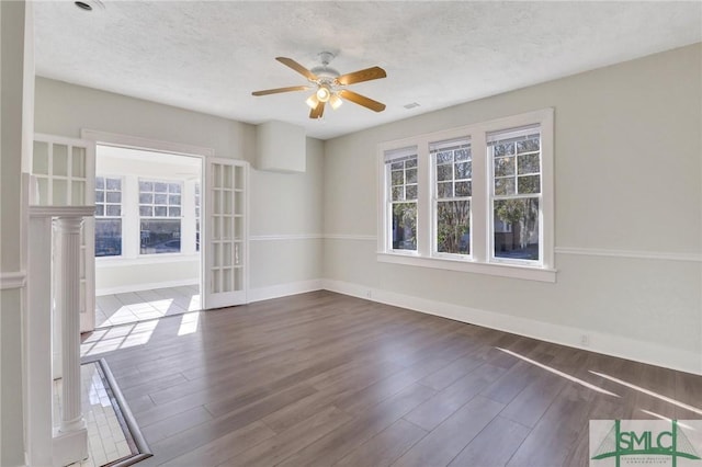 unfurnished room featuring a textured ceiling, dark hardwood / wood-style floors, and ceiling fan