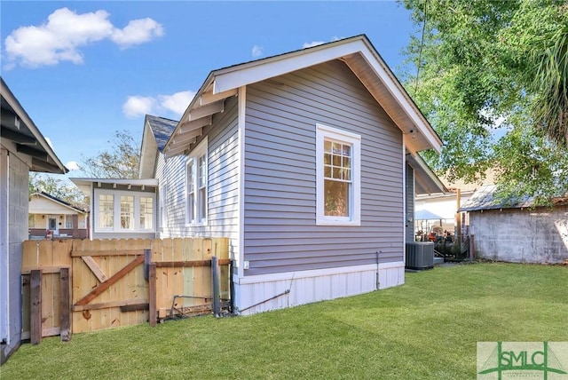 view of home's exterior with cooling unit and a yard