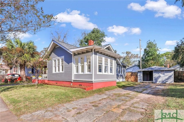 view of side of home with a storage shed and a lawn