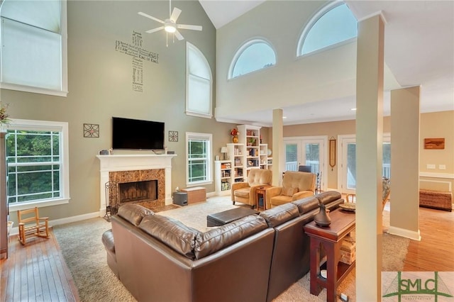 living room with ceiling fan, high vaulted ceiling, and light hardwood / wood-style flooring