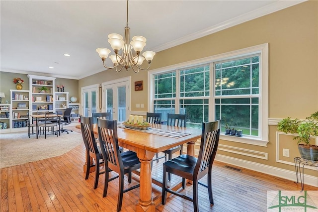 dining room featuring crown molding, hardwood / wood-style flooring, and a wealth of natural light