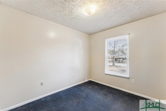 unfurnished room featuring a textured ceiling and dark colored carpet