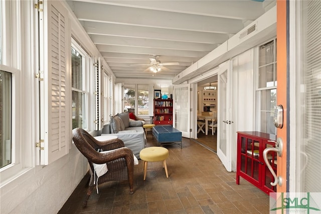 sunroom / solarium with ceiling fan, beam ceiling, and a healthy amount of sunlight