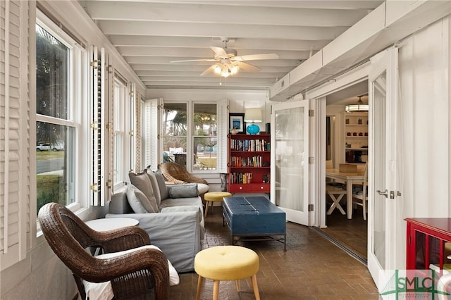 sunroom with ceiling fan, a healthy amount of sunlight, and beam ceiling