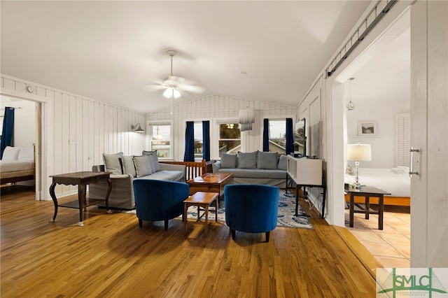 living room featuring vaulted ceiling, ceiling fan, and hardwood / wood-style floors