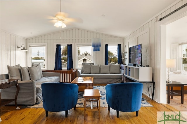 living room featuring vaulted ceiling, hardwood / wood-style floors, and wood walls