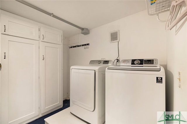 laundry area with separate washer and dryer and cabinets