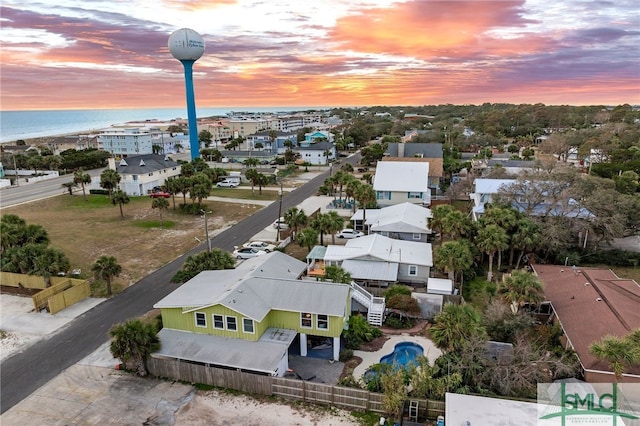 aerial view at dusk featuring a water view