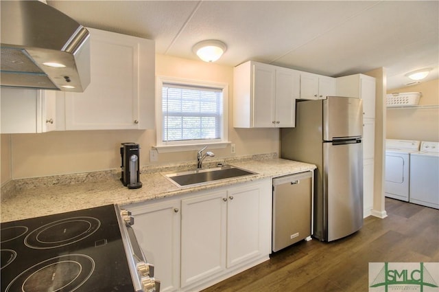 kitchen featuring sink, washer and clothes dryer, white cabinetry, stainless steel appliances, and ventilation hood