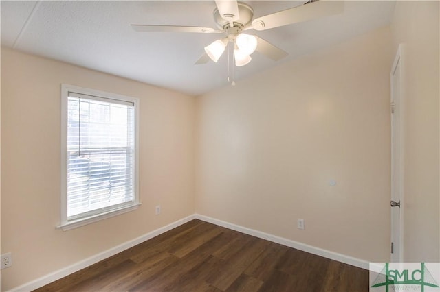 spare room with dark wood-type flooring and ceiling fan