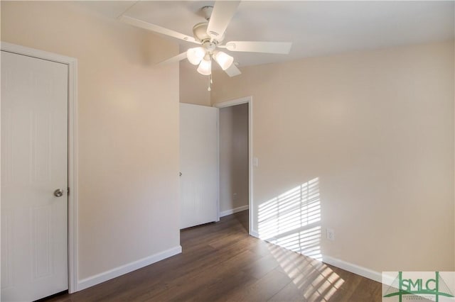 unfurnished room with ceiling fan and dark hardwood / wood-style flooring