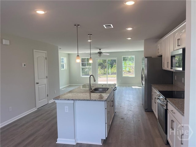 82 Marsh Salt Ln, Port Wentworth, GA 31407 - kitchen featuring stainless steel microwave, a sink, range with electric stovetop, an island with sink, and white cabinetry