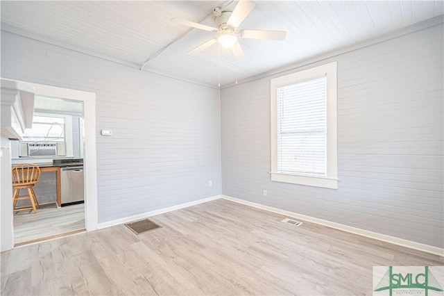 spare room featuring baseboards, cooling unit, wood finished floors, and visible vents