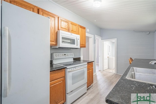 kitchen with white appliances, lofted ceiling, sink, and light wood-type flooring