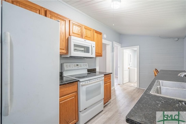 kitchen with white appliances, a sink, and light wood finished floors
