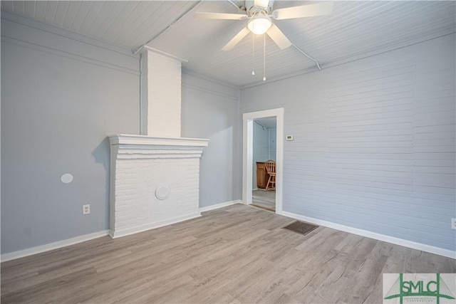 unfurnished living room featuring a ceiling fan, baseboards, visible vents, and wood finished floors