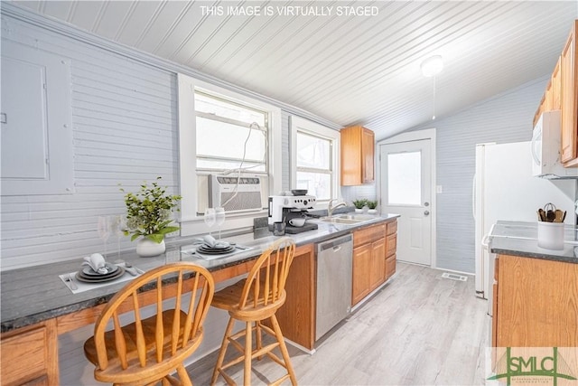 kitchen featuring a sink, dishwasher, light wood-style flooring, lofted ceiling, and white microwave