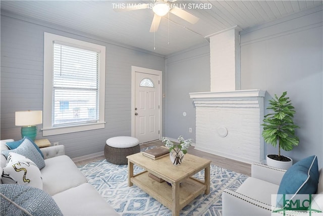 living room with baseboards, ceiling fan, and wood finished floors