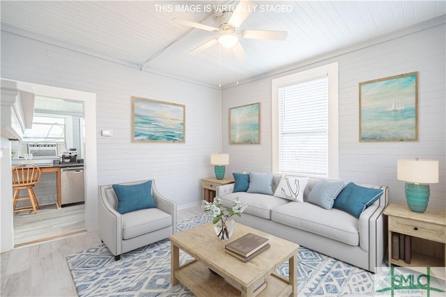 living area featuring plenty of natural light, a ceiling fan, wood ceiling, and light wood finished floors